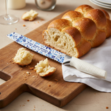 Challah knife on wooden board with bread