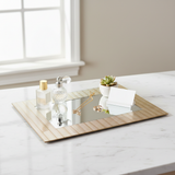 Gold mirror tray styled with decorative items on marble