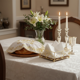 Napkin holder on Shabbat table with challah and candles