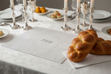 Shabbat challah board with candlelight setting
